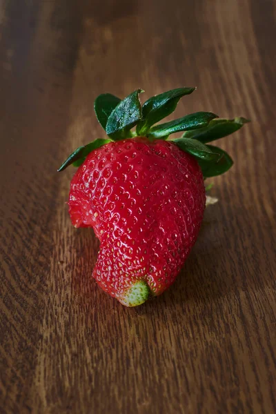 木桌上咬一口的草莓 — 图库照片