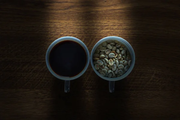 Чашка Нежареными Кофейными Зернами Чашка Жидким Кофе Рядом Окном — стоковое фото