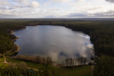 Yaz boyunca ormandaki göl kenarındaki kulübelerin insansız hava aracı görüntüsü.