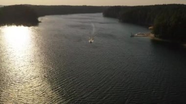 Yaz günü bir gölde yelken açan tekne görüntüsü