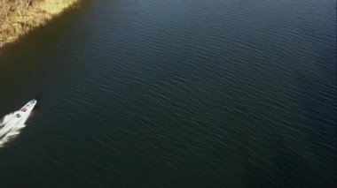 Yaz günü bir gölde yelken açan tekne görüntüsü