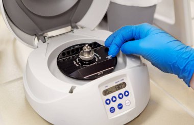 Bilim adamı ya da teknisyen termosiklet PCR makinesindeki eldivenli ellere örnek veriyor. Laboratuvar ekipmanları. DNA kopyası olan bir bilim adamı. Kimya öğrencileri bir deney yapıyor. Laboratuvarda DNA testi..