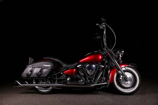 red motorcycle chopper with a high handlebar on a black background