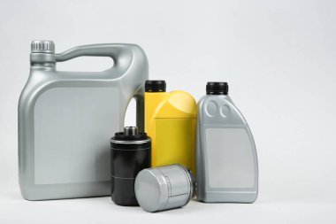 Beyaz arka planda araba yağı kutuları ve filtreler var. Arabalar için teknik sıvılar