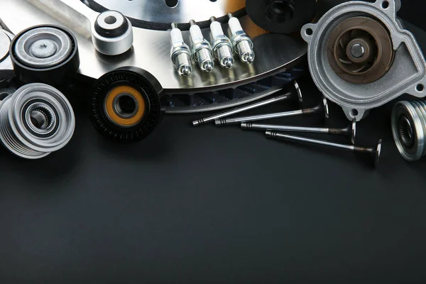 car parts on black background with copy space. dark template of auto spare parts. spark plugs, valves and other parts of a car engine on a black background with empty space