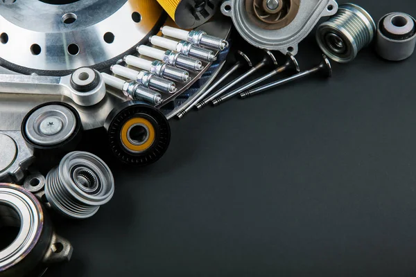 car parts on black background with copy space. dark template of auto spare parts. spark plugs, valves and other parts of a car engine on a black background with empty space