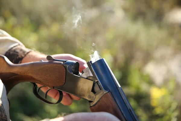 Caçador Segurando Uma Arma Fumegante Perto Uma Mão Homem Recarrega — Fotografia de Stock