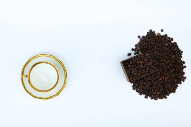 kavrulmuş kahve çekirdekleri ve beyaz arka planda fotokopi alanı olan beyaz porselen bardak manzarası.