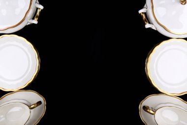 Siyah bir arkaplan üzerinde yaldızlı porselen tablo gereçleri kopya alanı ile yatıyordu