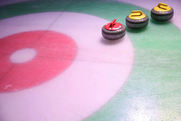 colorful curling stones on ice near the home background with copy space