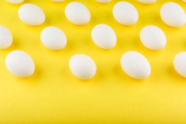 Sarı arka planda beyaz tavuk yumurtaları.