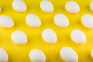 Sarı arka planda beyaz tavuk yumurtaları.