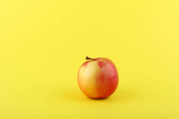 red apple on yellow background with copy space