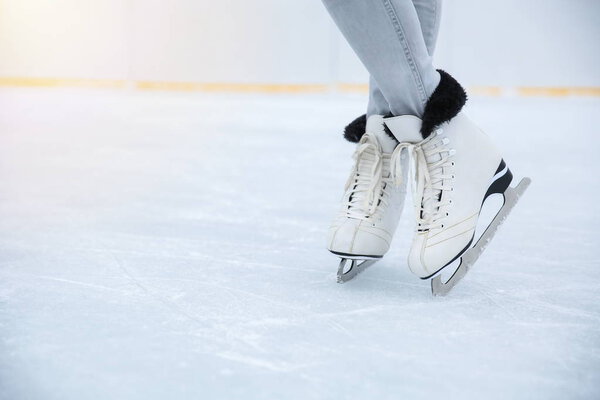 white ice skates is on female legs close up on the ice