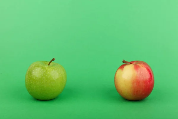 green and red apples on green background