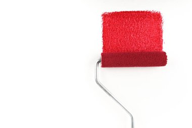 Beyaz arkaplanda kırmızı boya ve boya silindiri