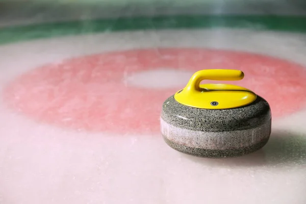 curling stone is on ice near the home colorful background