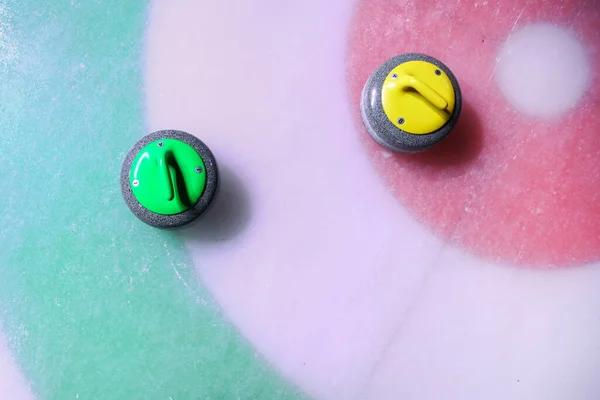 curling stone is on ice near the home colorful background