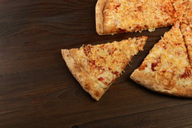 Kahverengi ahşap üzerinde rustik tarzda peynirli pizza kompozisyonu
