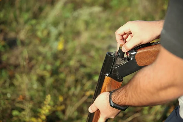 ハンターの手が近くの森の狩猟用ライフルをリロード — ストック写真