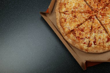 Koyu arkaplanda kopyalama alanı olan kırsal tarzda üst görünümde pizza