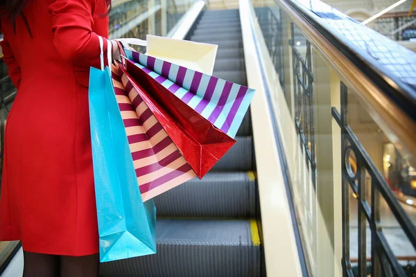 female with shopping bags in the mall close up without face