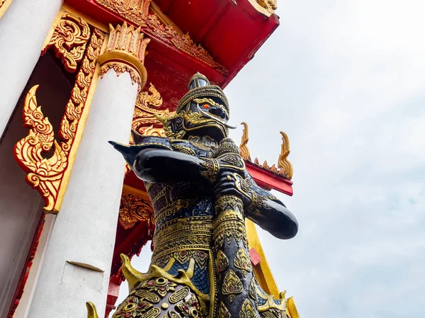 Giant guarding the temple gate,In red eyes black gold dress and holding a club,Temple name is Wat kaew at Bangkok Thailand