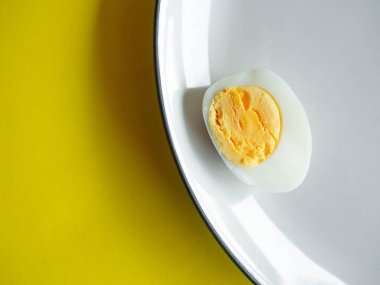 Haşlanmış yumurta, beyaz bir tabakta Cayenne biberi ve tuz, yumurta rengi beyaz ve sarı, ekmekle ye.