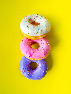 Donutlar çeşitli renklerde turuncu beyaz pembe, yüksek enerji gıdaları ve sağlıklı oranlar, tatlı aromalı şekerler, eşleştirme arka planı