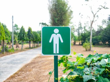 Yeşil etiketli. Kişinin arkası doğal yeşil alandır..