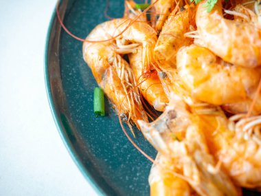 Fırında karides kabuğu, tuzlu, kurbağa, parfüm için sarımsak taze soğanlı garnitür ve yuvarlak bir tabakta kişniş.