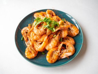 Fırında karides kabuğu, tuzlu, kurbağa, parfüm için sarımsak taze soğanlı garnitür ve yuvarlak bir tabakta kişniş.