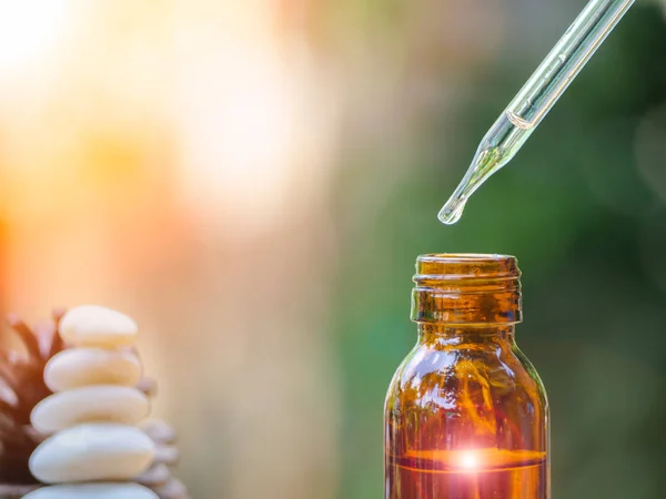 The essential oil falling from glass dropper into organic bio al — Stock Photo, Image