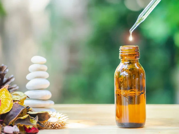 The essential oil falling from glass dropper into organic bio al — Stock Photo, Image