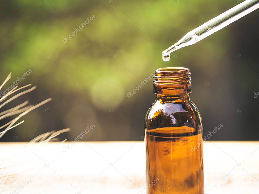 The essential oil falling from glass dropper into organic bio al