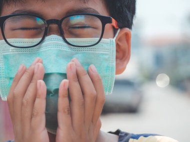 Pm2.5, Coronavirus ve sis 'i korumak için maske takan küçük bir çocuk dışarı çıktığında Coronavirus salgınını durdurur. Soğuk algınlığı ve bronşit belirtileri gibi öksürük ve iyi hissetmemek. Sağlık hizmetleri kavramı.