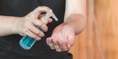 Asyalı kadın şişeden alkol jeli sürüyor ve temizlik için dezenfektan jeli yıkıyor, Covid-19 virüsünü korumak için bakteri ve virüs temizliyor. Pandemik koruma, hijyenik konsept