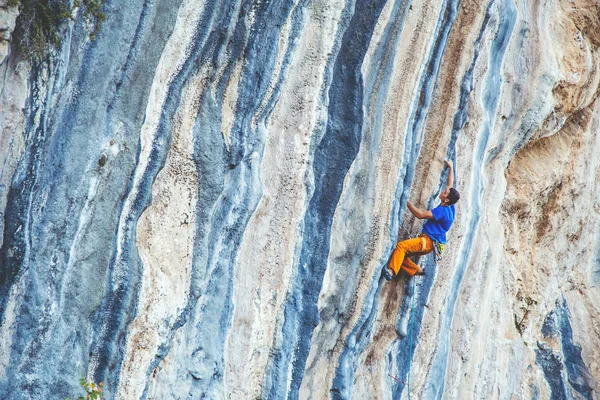 Uomo arrampicata su una roccia. — Foto Stock