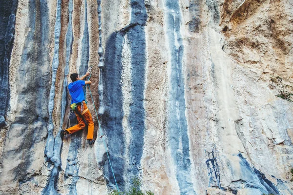 Uomo arrampicata su una roccia. — Foto Stock