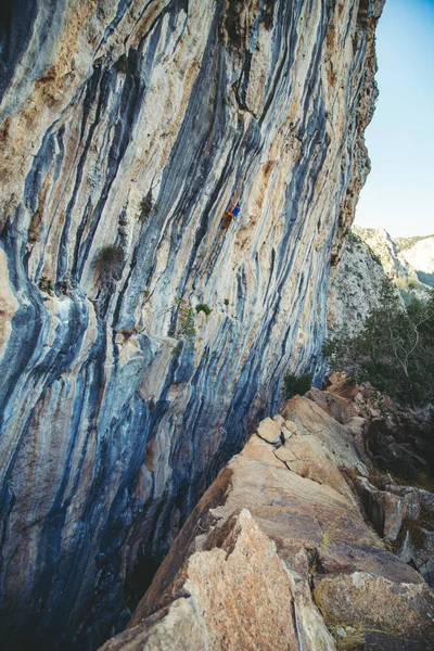 Uomo arrampicata su una roccia. — Foto Stock