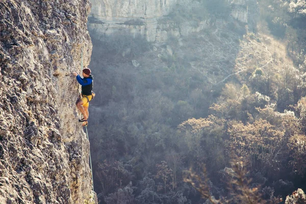 Człowiek wspina się na skałę. — Zdjęcie stockowe