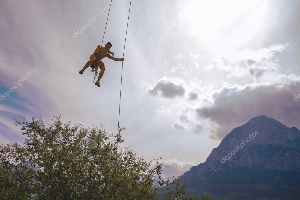 Man hanging on a rope.