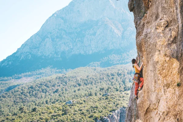 Meisje klimt op een rots. — Stockfoto