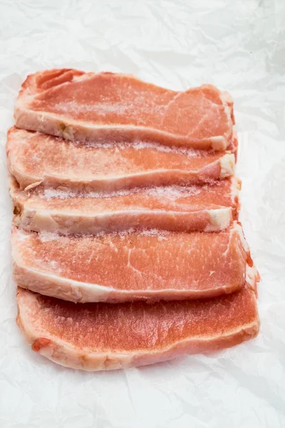 Frozen meat steaks on white background