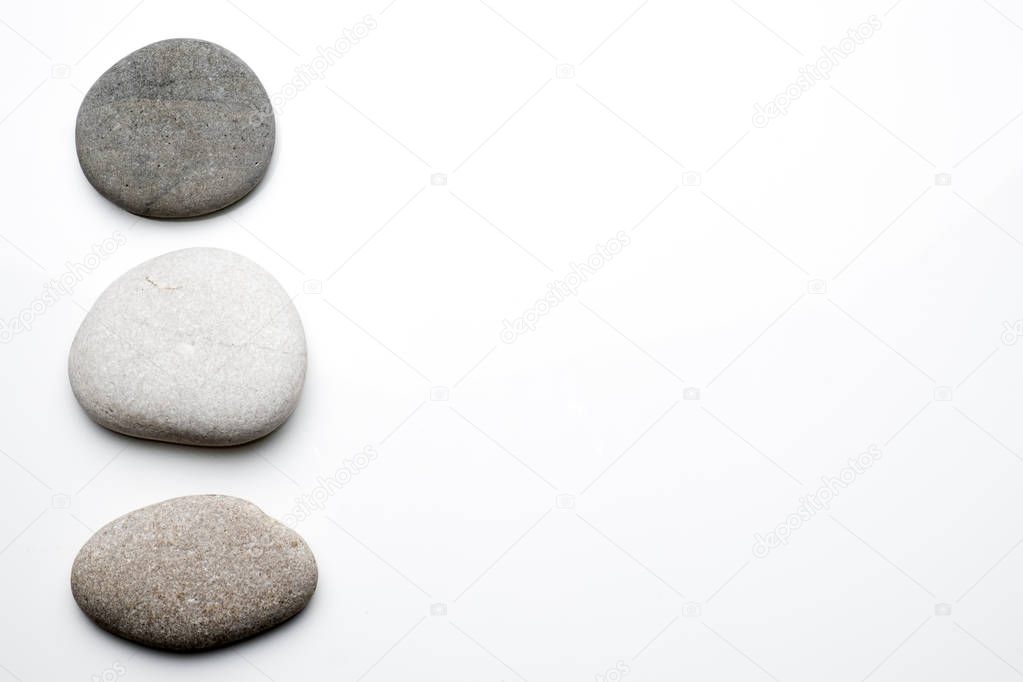 Smooth round stones on a white background with copy space