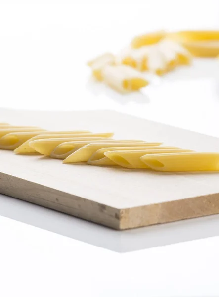 Pasta penne with cutting board — Stock Photo, Image