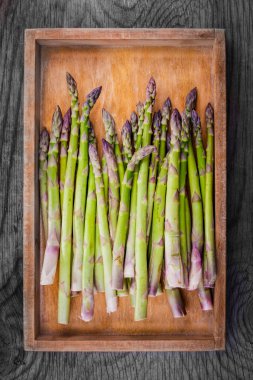Tahtaya dizilmiş taze biçilmiş kuşkonmaz.