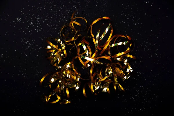 Χρυσές σερπαντίνες σε μαύρο φόντο — Φωτογραφία Αρχείου