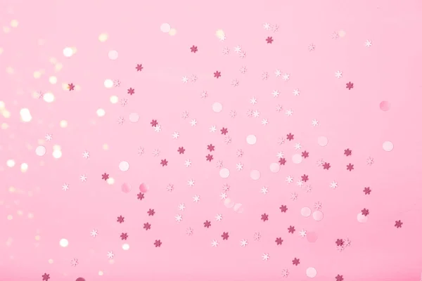 Små snöflingor konfetti på rosa bakgrund — Stockfoto