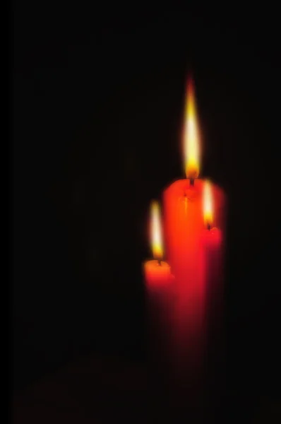 Rozostření červenou svíčku a osvětlení na černém pozadí — Stock fotografie